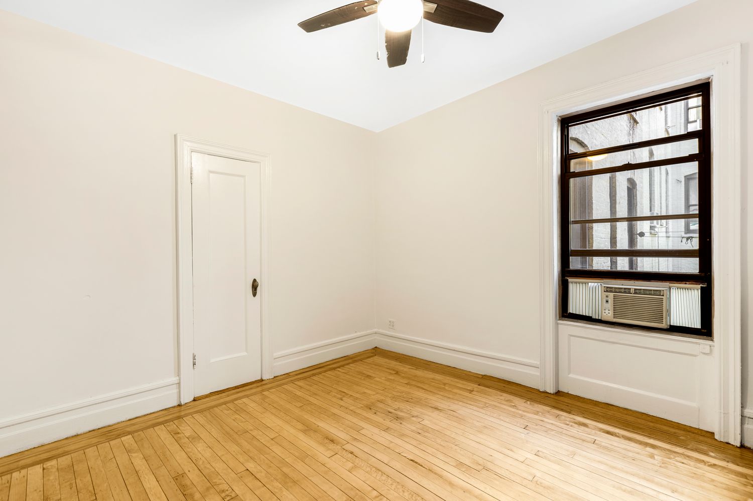 an empty room with cabinet and windows