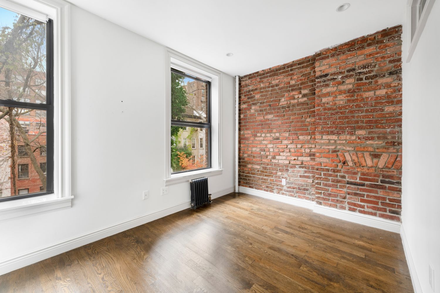 51 West 11th Street, Unit 3R Manhattan, NY 10011 - Photo 3 of 5 an empty room with wooden floor and windows