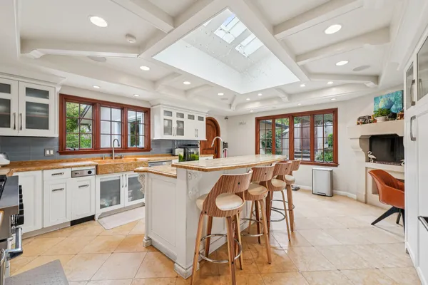 a kitchen with a dining table chairs cabinets and stainless steel appliances