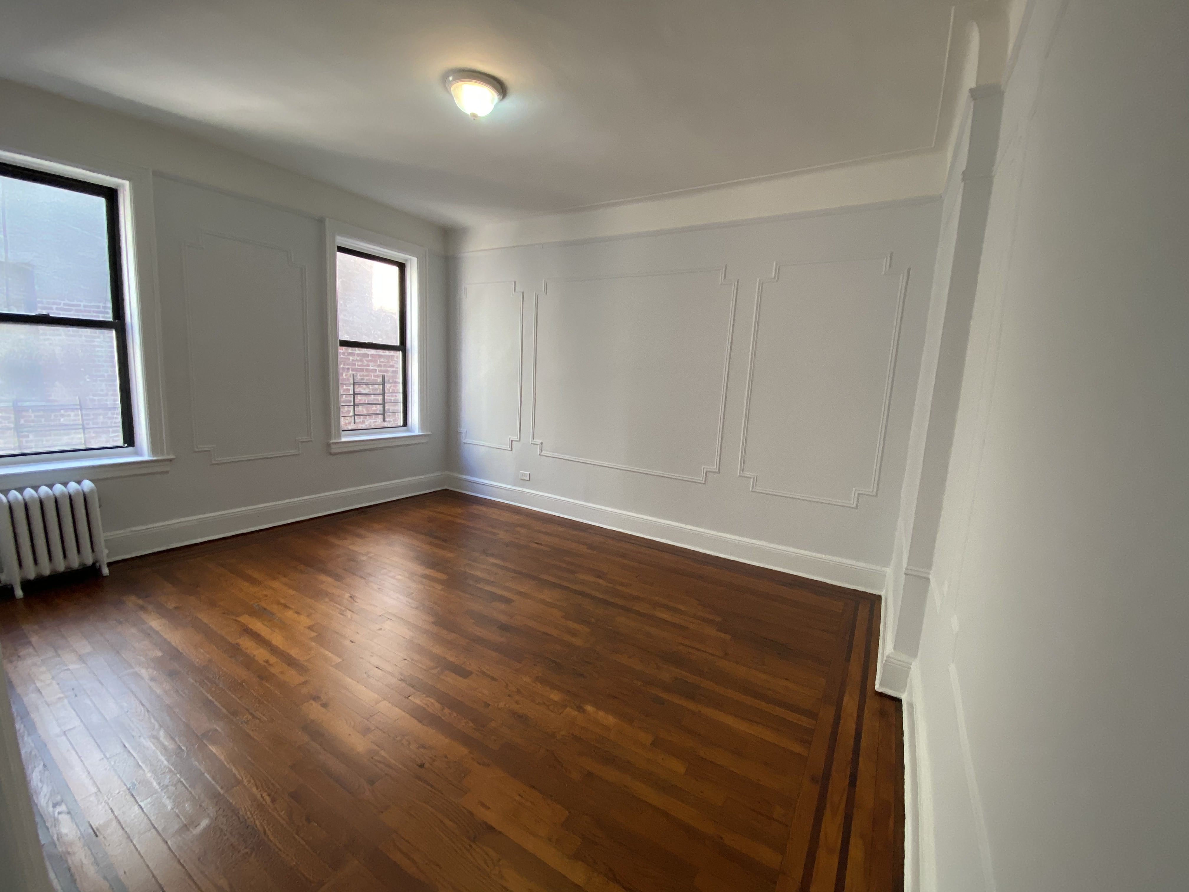 28-23 42nd Street, Unit C3 Queens, NY 11103 - Photo 2 of 6 an empty room with wooden floor and windows