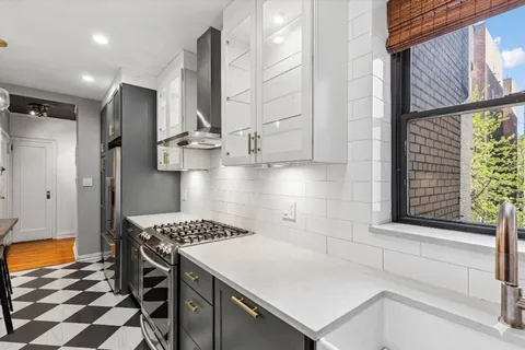 a kitchen with stainless steel appliances granite countertop a stove a sink and a refrigerator