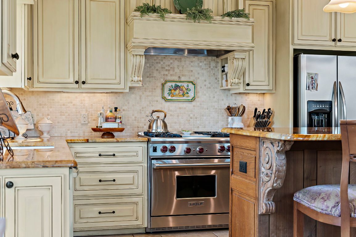 1607 The High Road Austin, TX 78746 - Photo 11 of 28 a kitchen with stainless steel appliances granite countertop a stove and a white cabinets