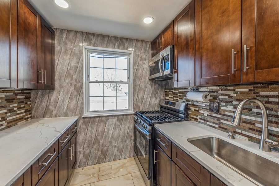 224-46 Horace Harding Expressway, Unit 630 Queens, NY 11364 - Photo 17 of 29 a kitchen that has a sink and a stove