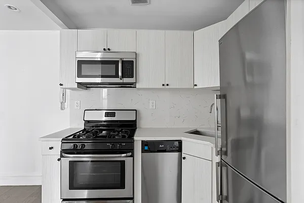 20 Avenue A, Unit 3AB Manhattan, NY 10009 - Photo 9 of 13 a kitchen with cabinets and stainless steel appliances