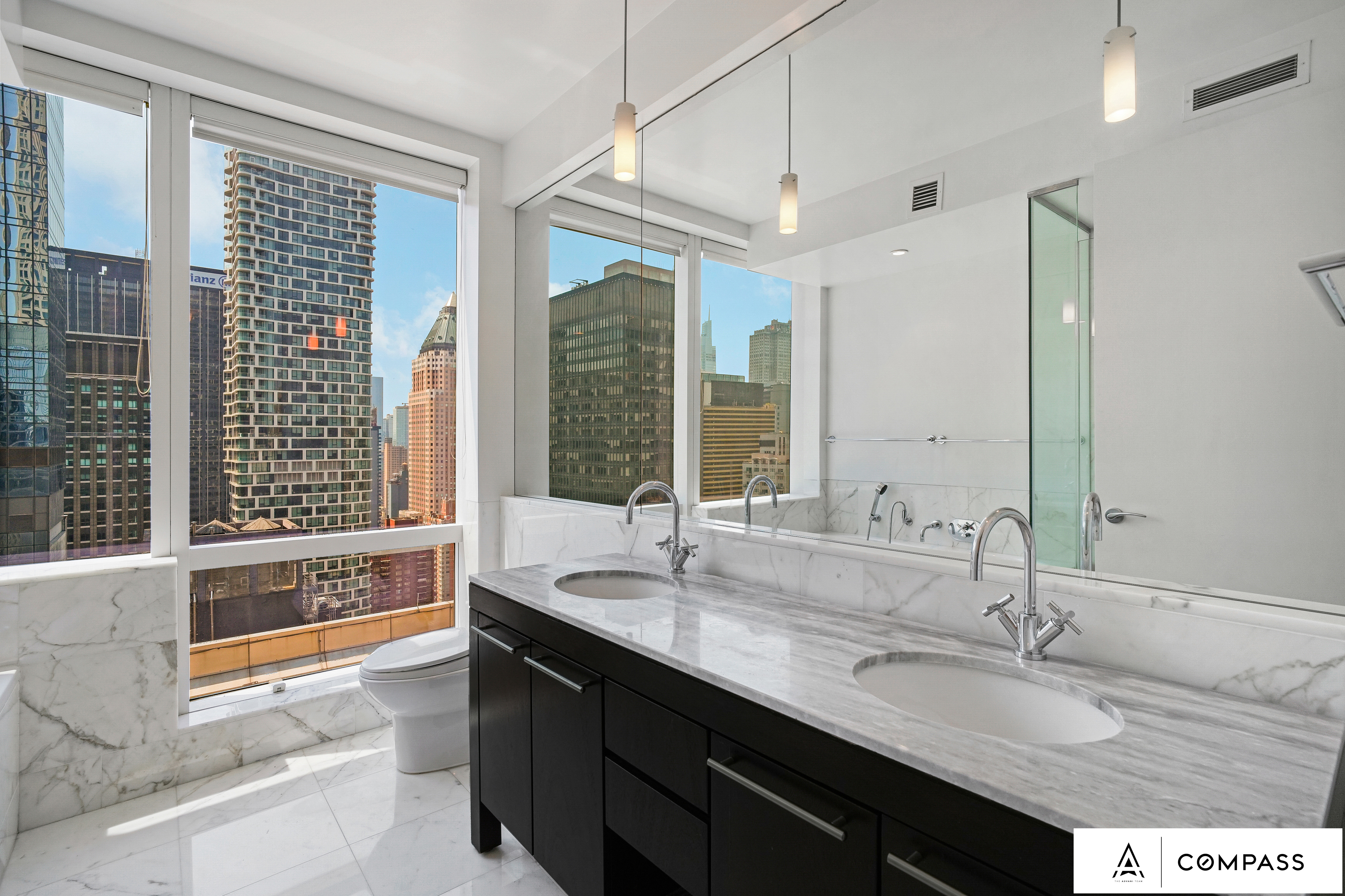 230 West 56th Street, Unit 49C Manhattan, NY 10019 - Photo 6 of 14 a spacious bathroom with sinks mirror and a bathtub