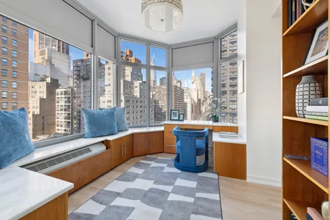 a large room with pool table and windows