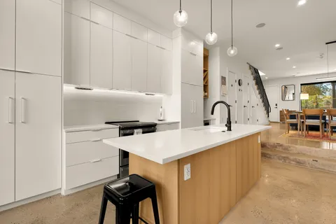 a kitchen with a sink a stove and chairs