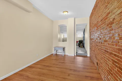 a view of a room with wooden floor and a staircase