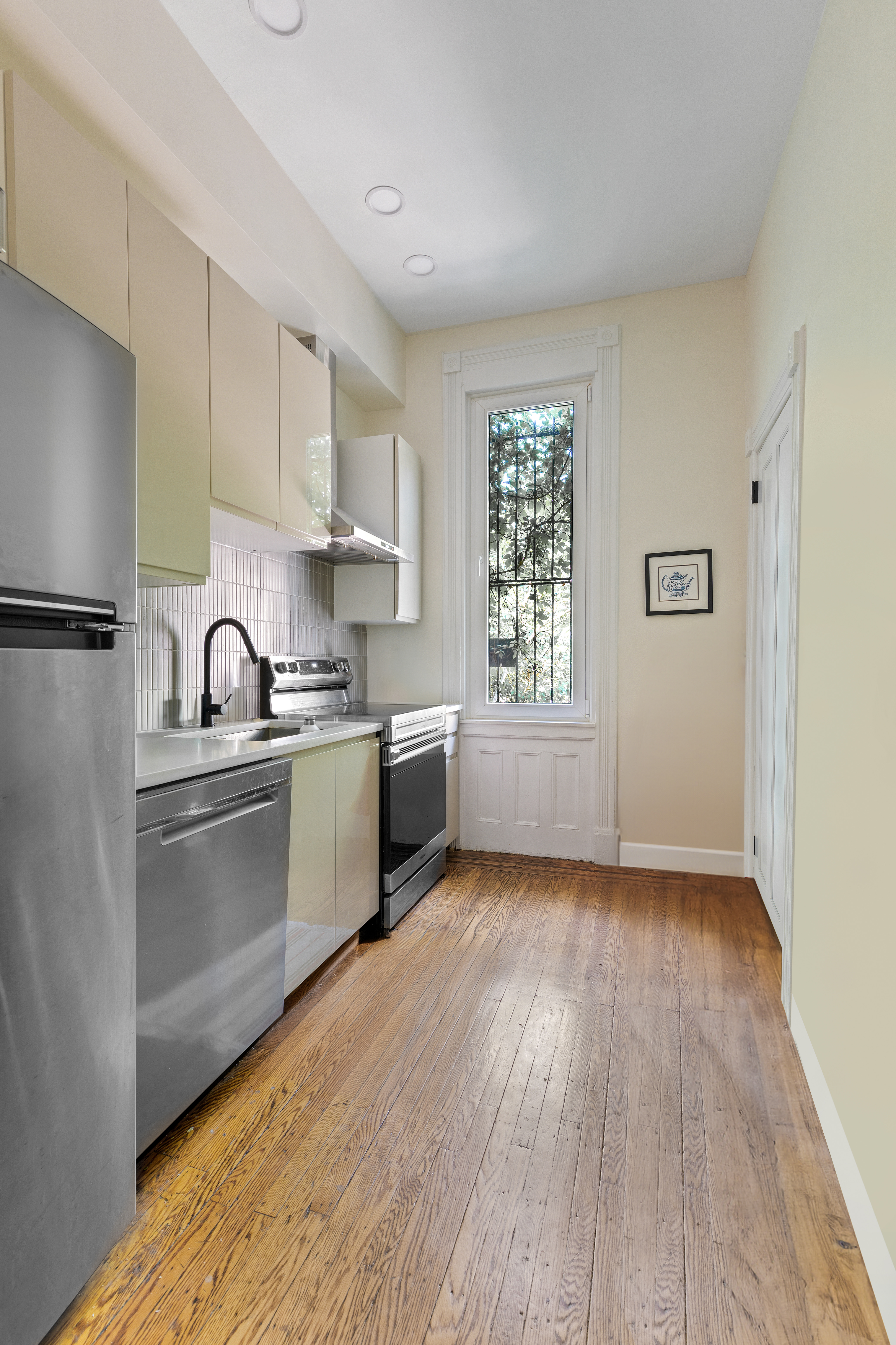 285 Weirfield Street Brooklyn, NY 11221 - Photo 11 of 16 a kitchen with granite countertop a sink cabinets stainless steel appliances and window