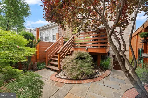 a view of a house with a small yard and sitting area