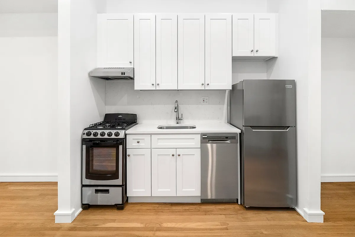 147 Sullivan Street, Unit 1A Manhattan, NY 10012 - Photo 4 of 6 a kitchen with stainless steel appliances granite countertop a refrigerator sink and stove