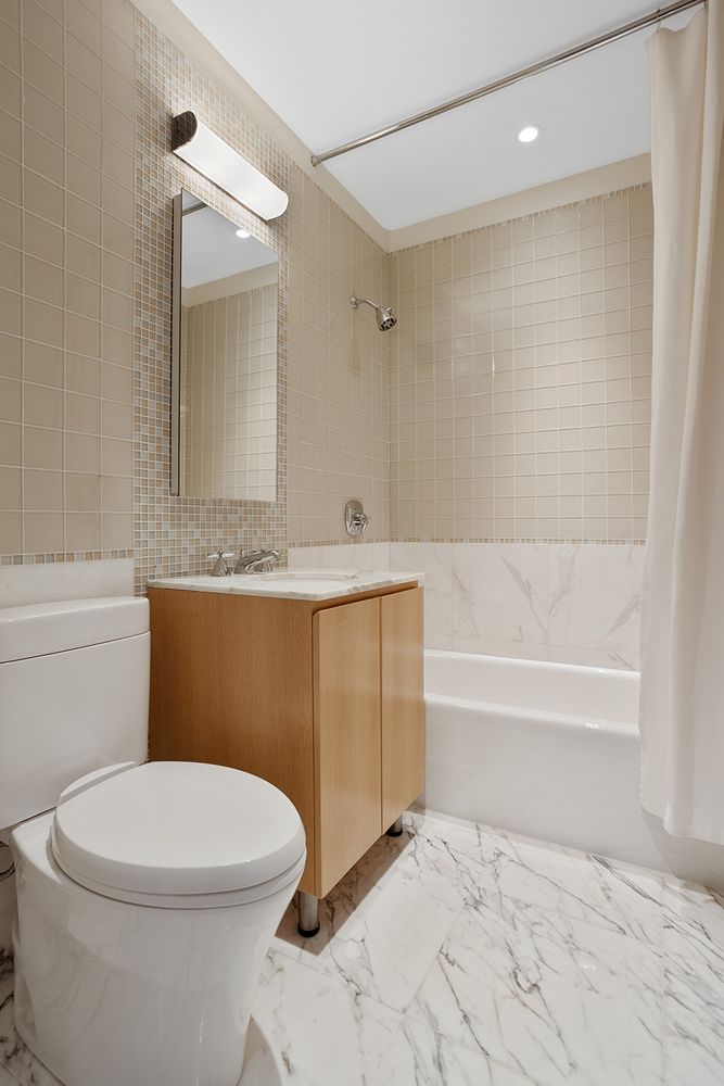 255 East 74th Street, Unit 20C Manhattan, NY 10021 - Photo 10 of 16 a bathroom with a toilet a sink and bathtub