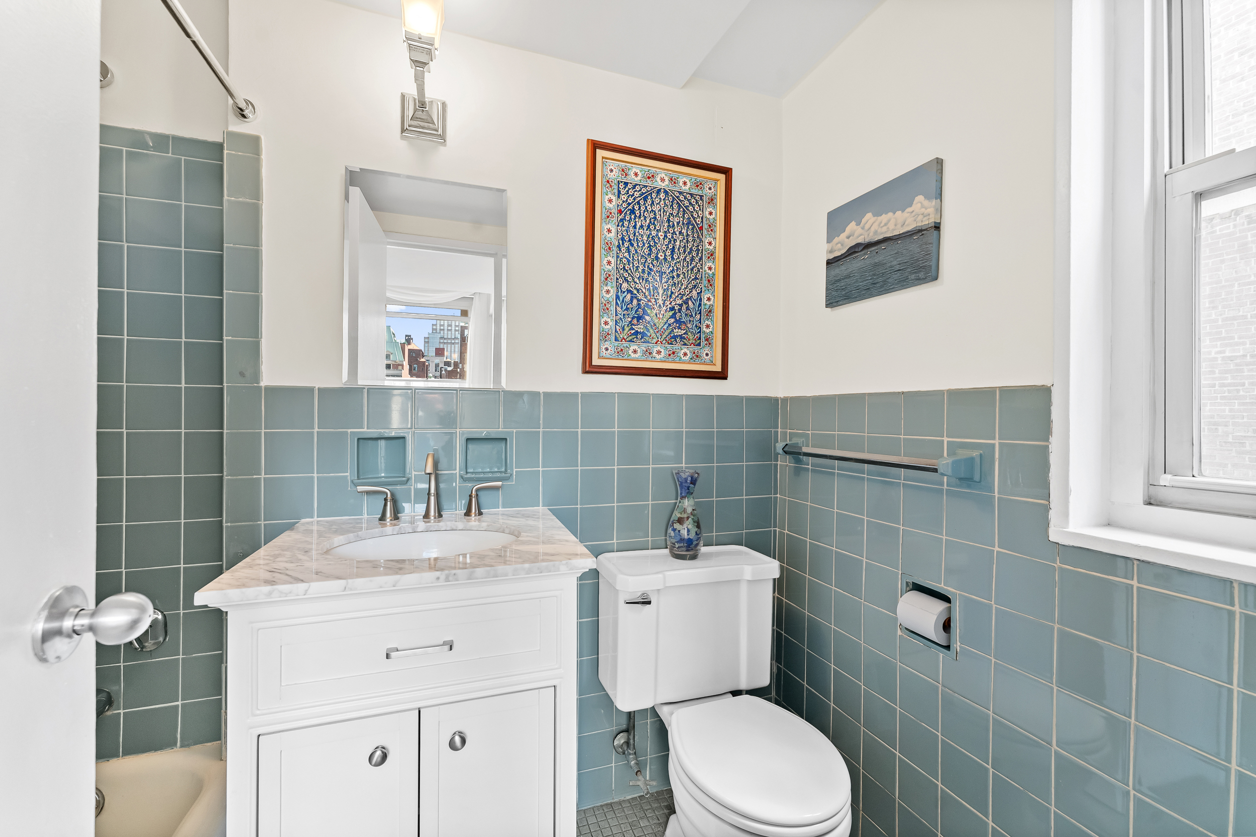 310 Lexington Avenue, Unit 15A Manhattan, NY 10016 - Photo 9 of 17 a bathroom with a toilet sink and mirror