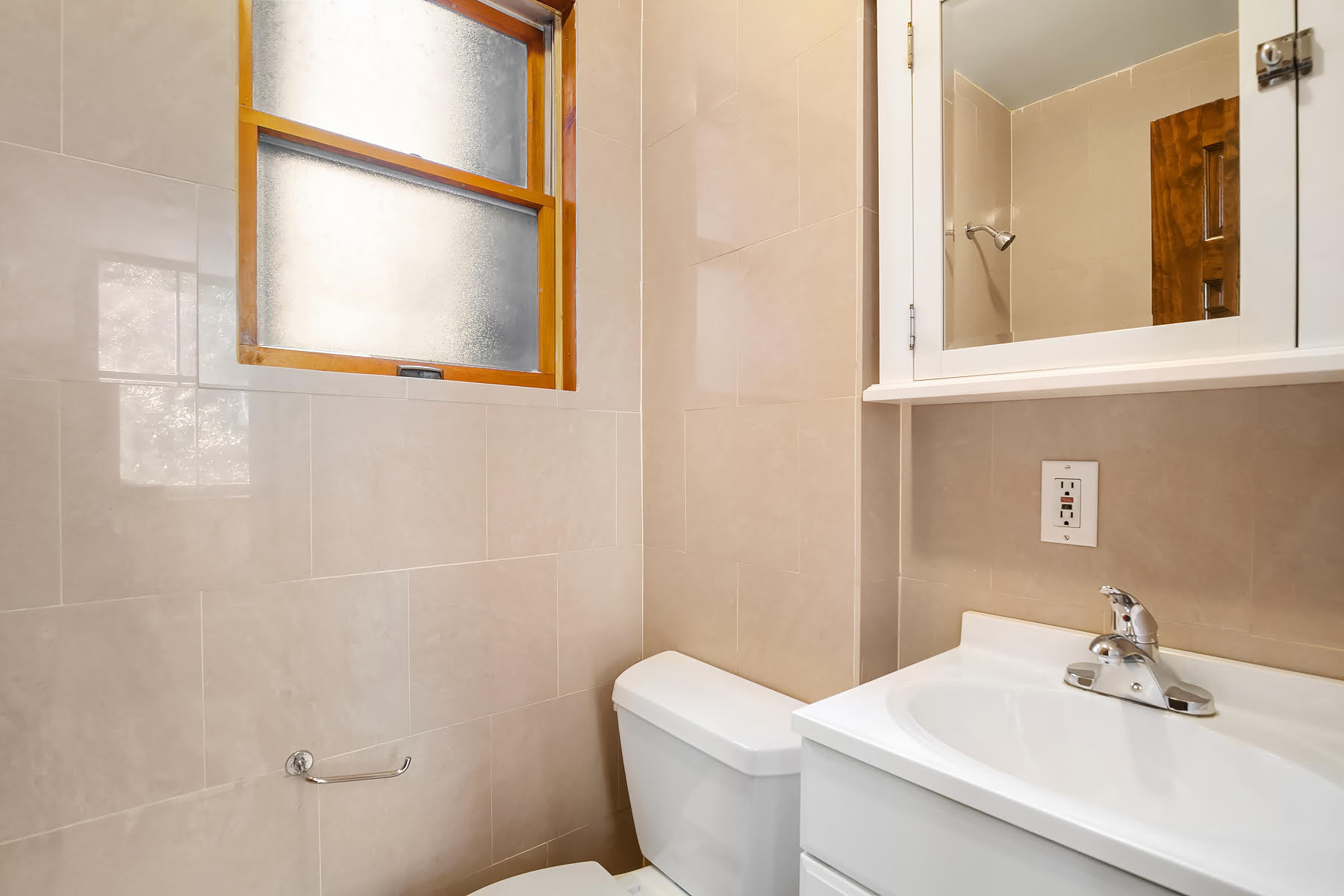 49 Perry Street, Unit 1E Manhattan, NY 10014 - Photo 3 of 3 a bathroom with a toilet a sink and mirror