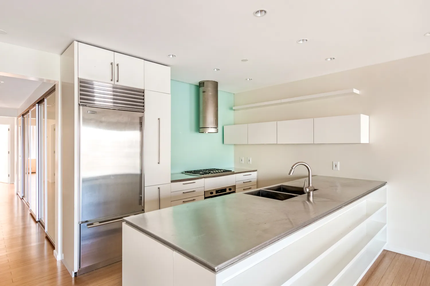 a kitchen with kitchen island a sink a refrigerator and counter space
