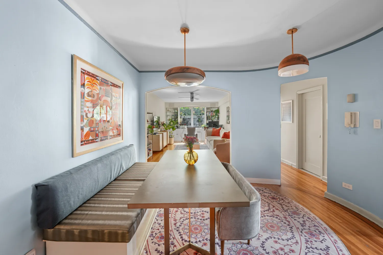 a dining room with wooden floor windows table and chairs