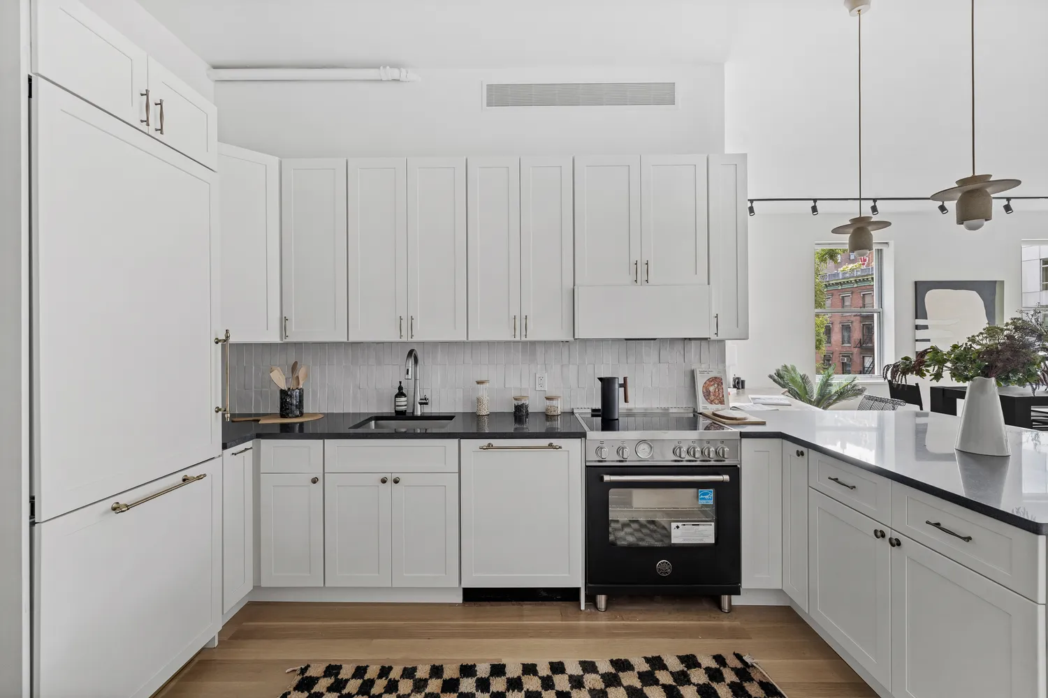 a kitchen with stainless steel appliances a stove a sink and white cabinets