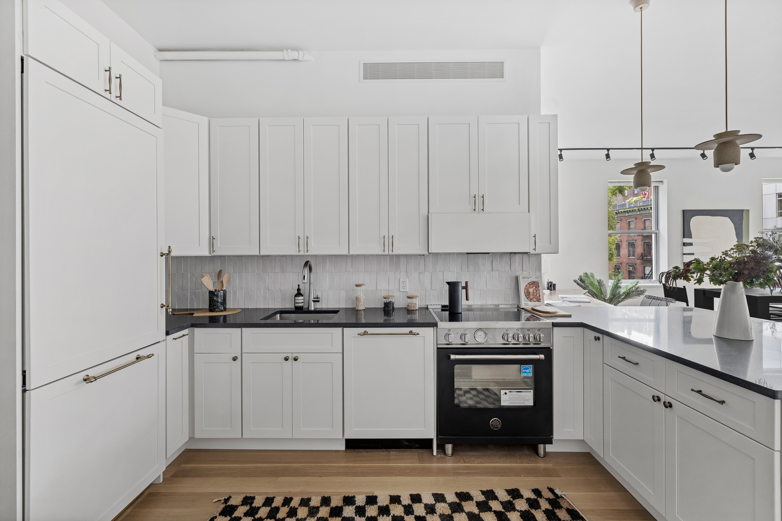 325 Bowery, Unit 3 Manhattan, NY 10003 - Photo 5 of 14 a kitchen with stainless steel appliances a stove a sink and white cabinets