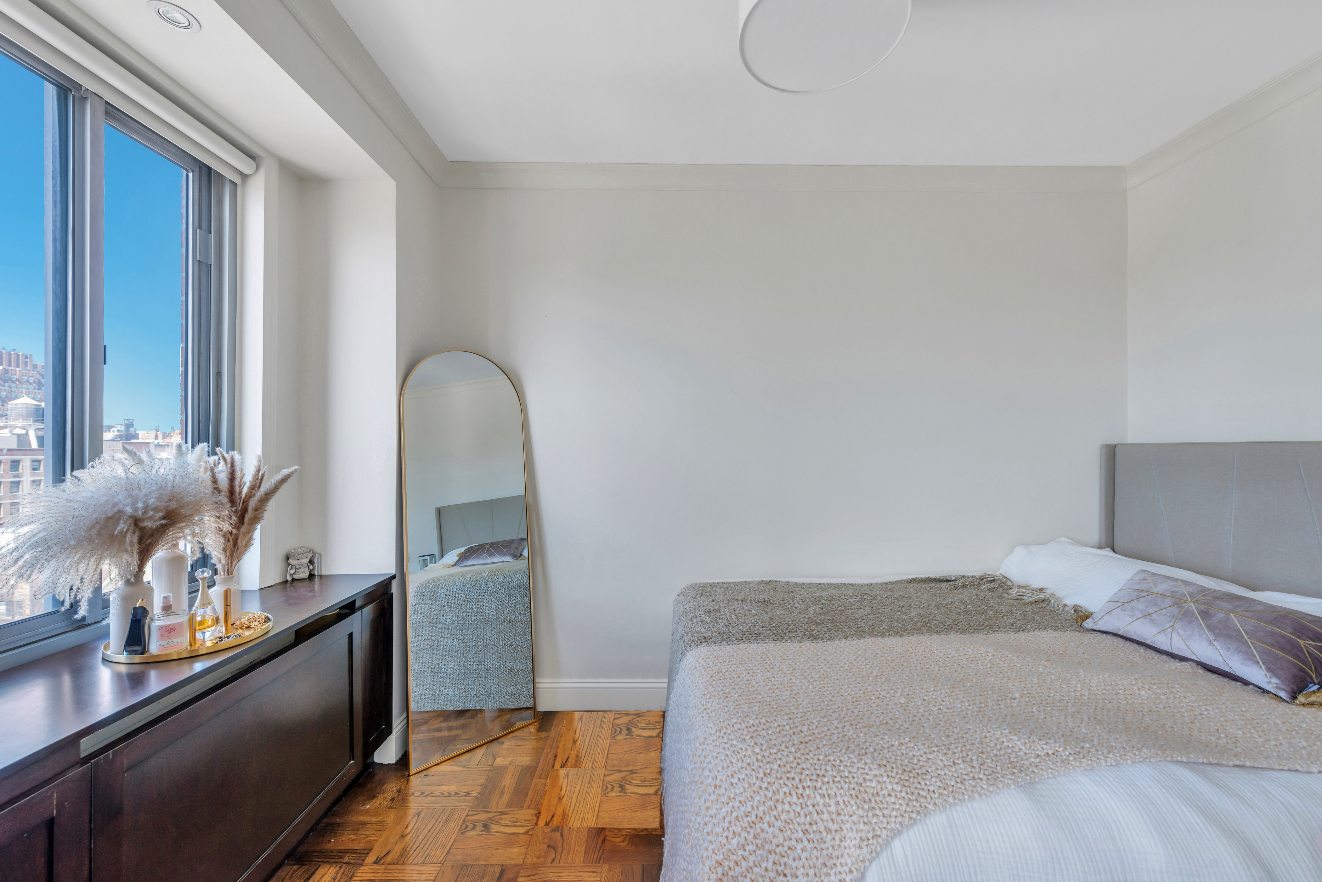 175 West 12th Street, Unit 12F Manhattan, NY 10011 - Photo 8 of 10 a bedroom with a bed and a dresser with potted plants