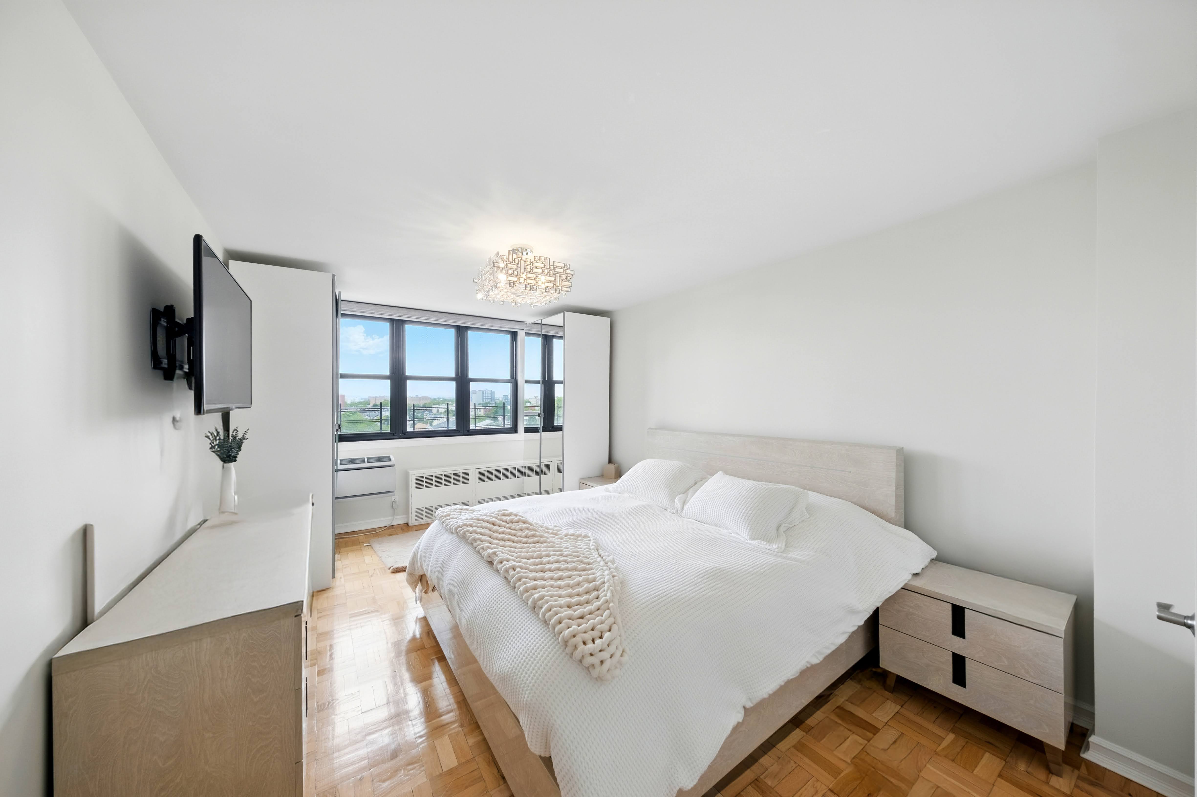 1360 Ocean Parkway, Unit 7B Brooklyn, NY 11230 - Photo 5 of 14 a spacious bedroom with a bed and a flat tv screen on a dresser