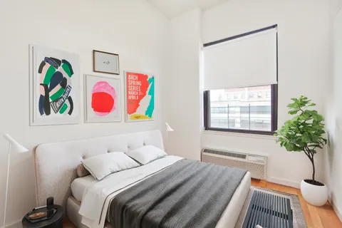 a bedroom with a bed and a potted plant