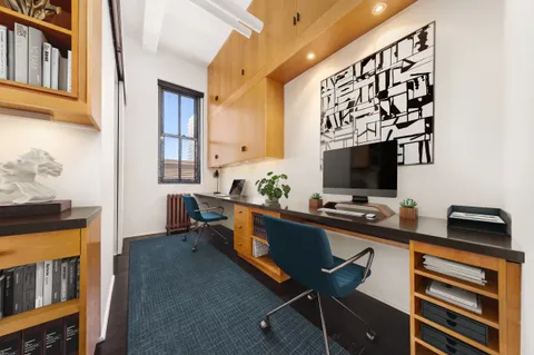 a living room with furniture a flat screen tv and a window