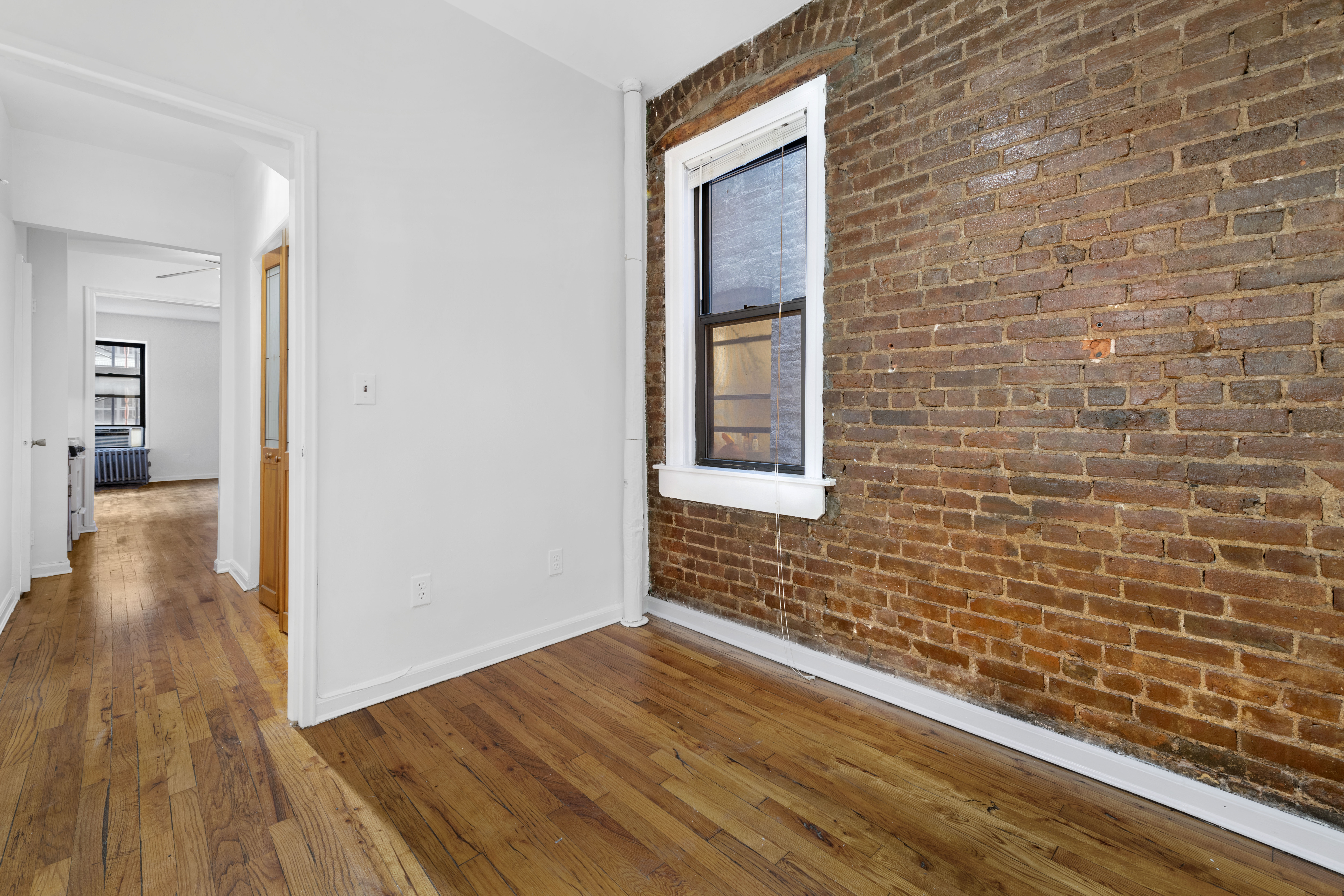 433 West 54th Street, Unit 20 Manhattan, NY 10019 - Photo 5 of 7 a view of an empty room and wooden floor