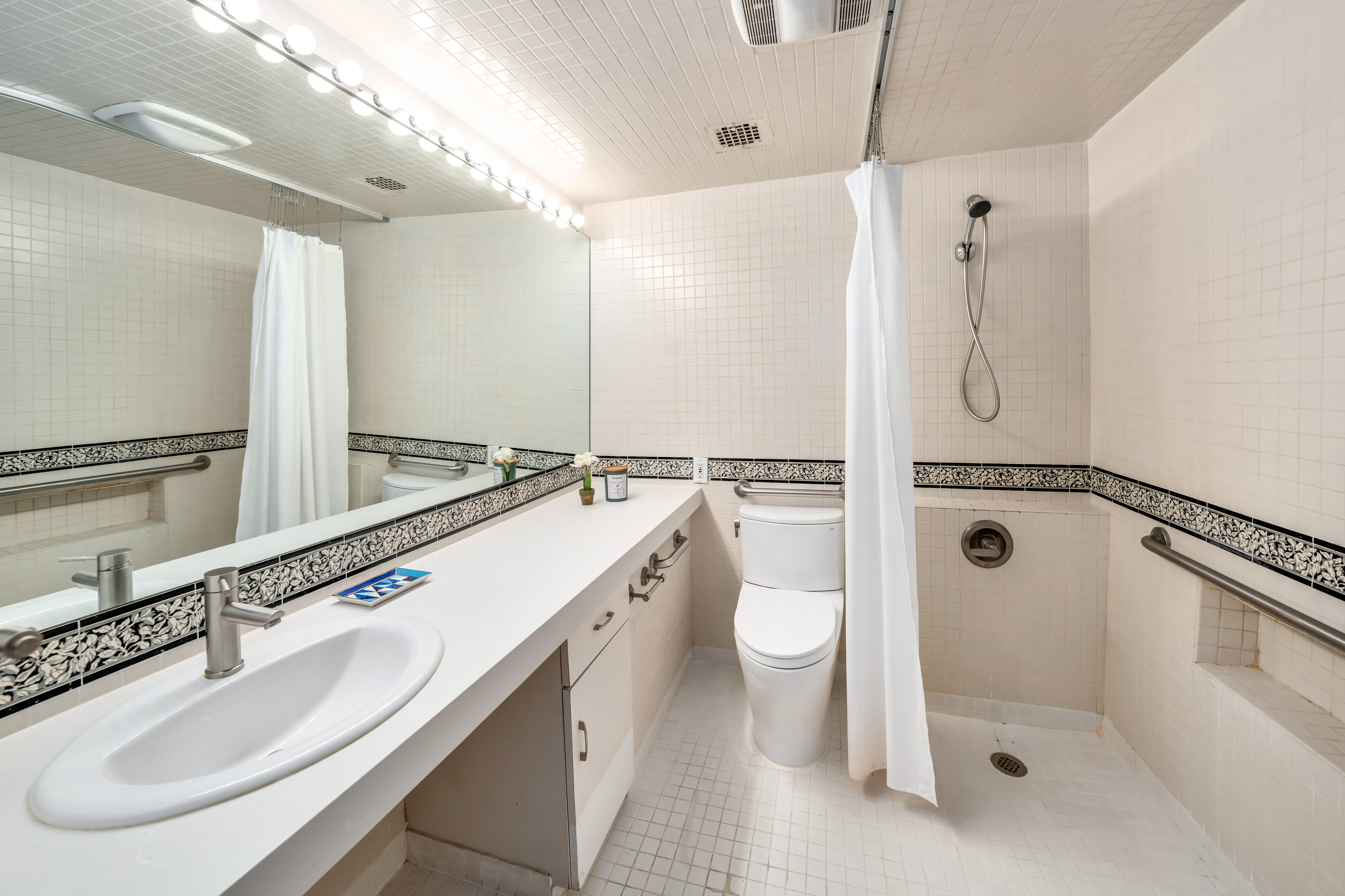 2166 Broadway, Unit 5C Manhattan, NY 10024 - Photo 5 of 11 a bathroom with a double vanity sink toilet mirror and shower