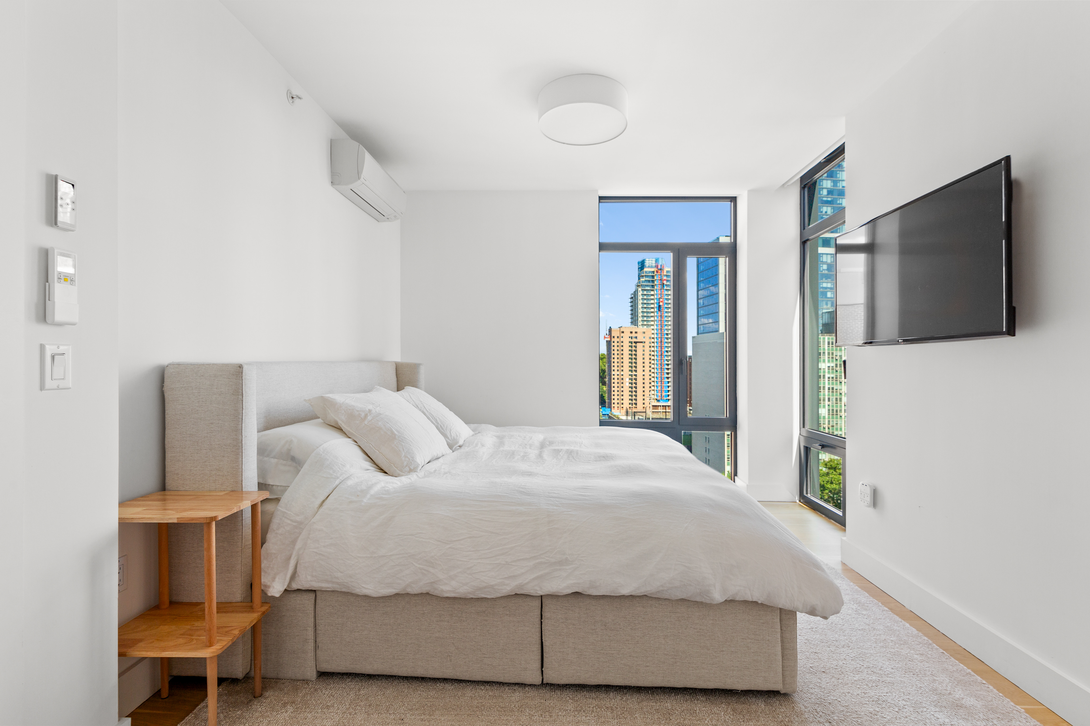 112 Fleet Place, Unit 12A Brooklyn, NY 11201 - Photo 9 of 15 a bedroom with a bed and a flat screen tv