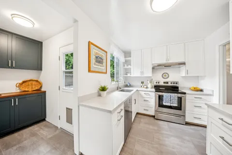 a kitchen with stainless steel appliances granite countertop a sink and a stove