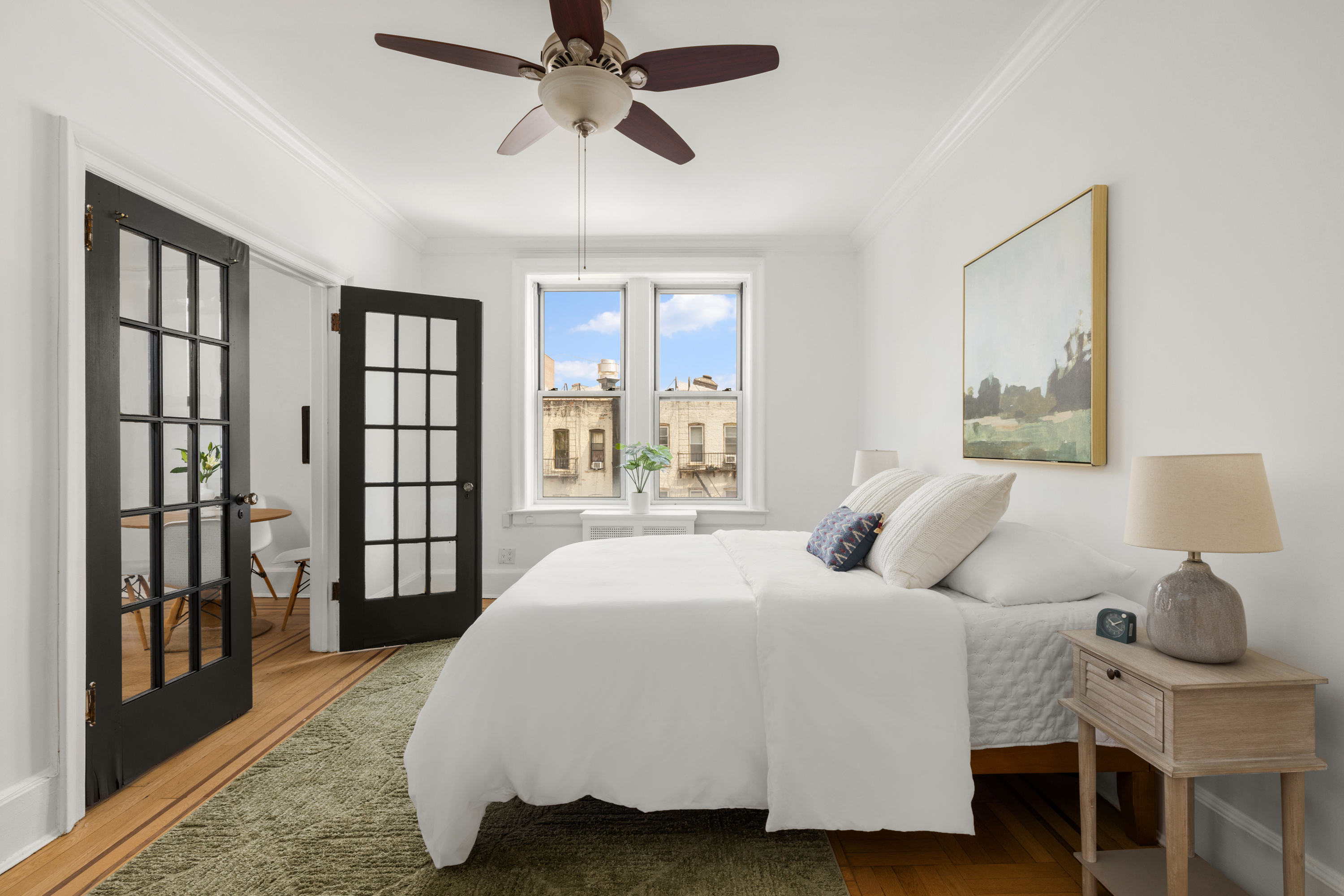759 42nd Street, Unit 14 Brooklyn, NY 11232 - Photo 4 of 9 a bedroom with a large bed and a chandelier fan