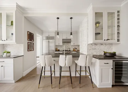 a kitchen with stainless steel appliances kitchen island granite countertop a table chairs in it and white cabinets