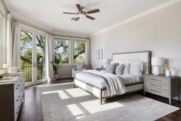 a spacious bedroom with a bed a couch and large window