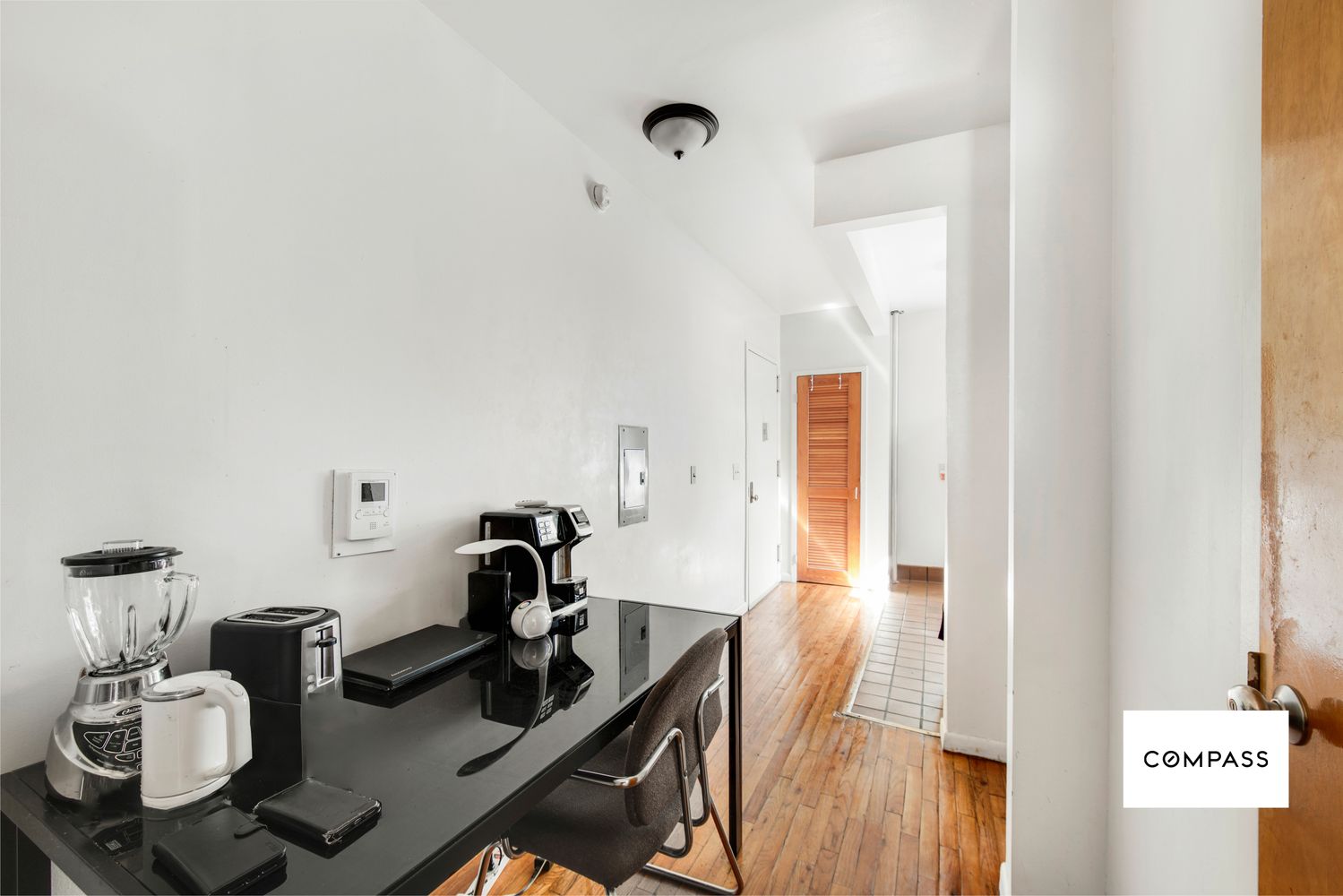 a view of a workspace with furniture and wooden floor