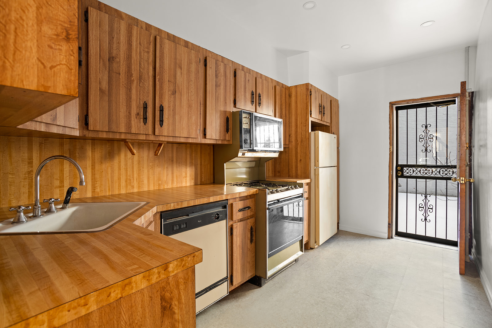 1682 8th Avenue Brooklyn, NY 11215 - Photo 8 of 16 a kitchen with stainless steel appliances granite countertop a refrigerator a stove and a sink with wooden cabinets