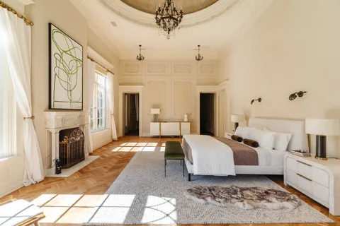 a spacious bedroom with a large bed and a fireplace
