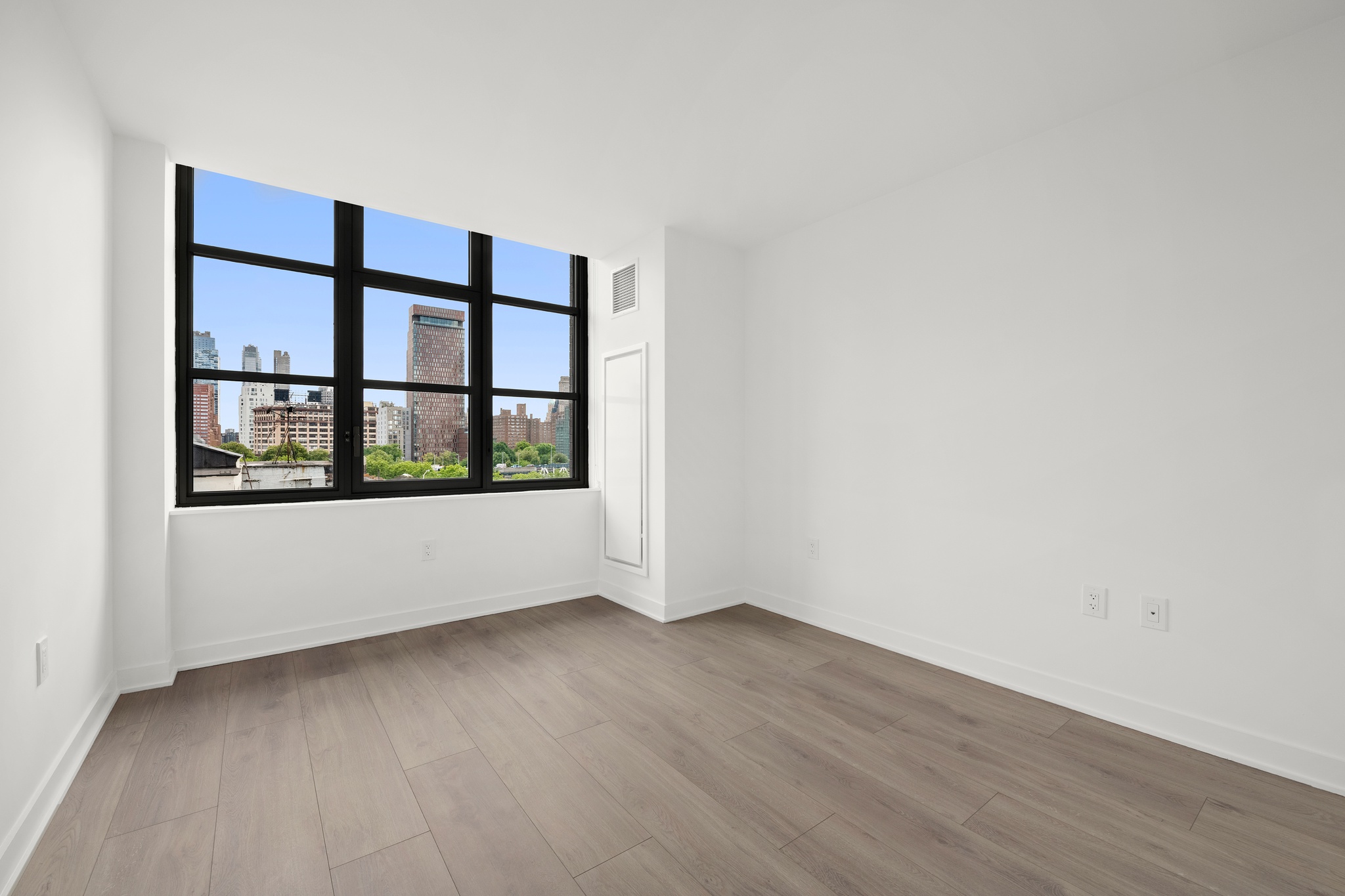 160 Front Street, Unit 706 Brooklyn, NY 11201 - Photo 7 of 17 a view of an empty room with wooden floor and a window