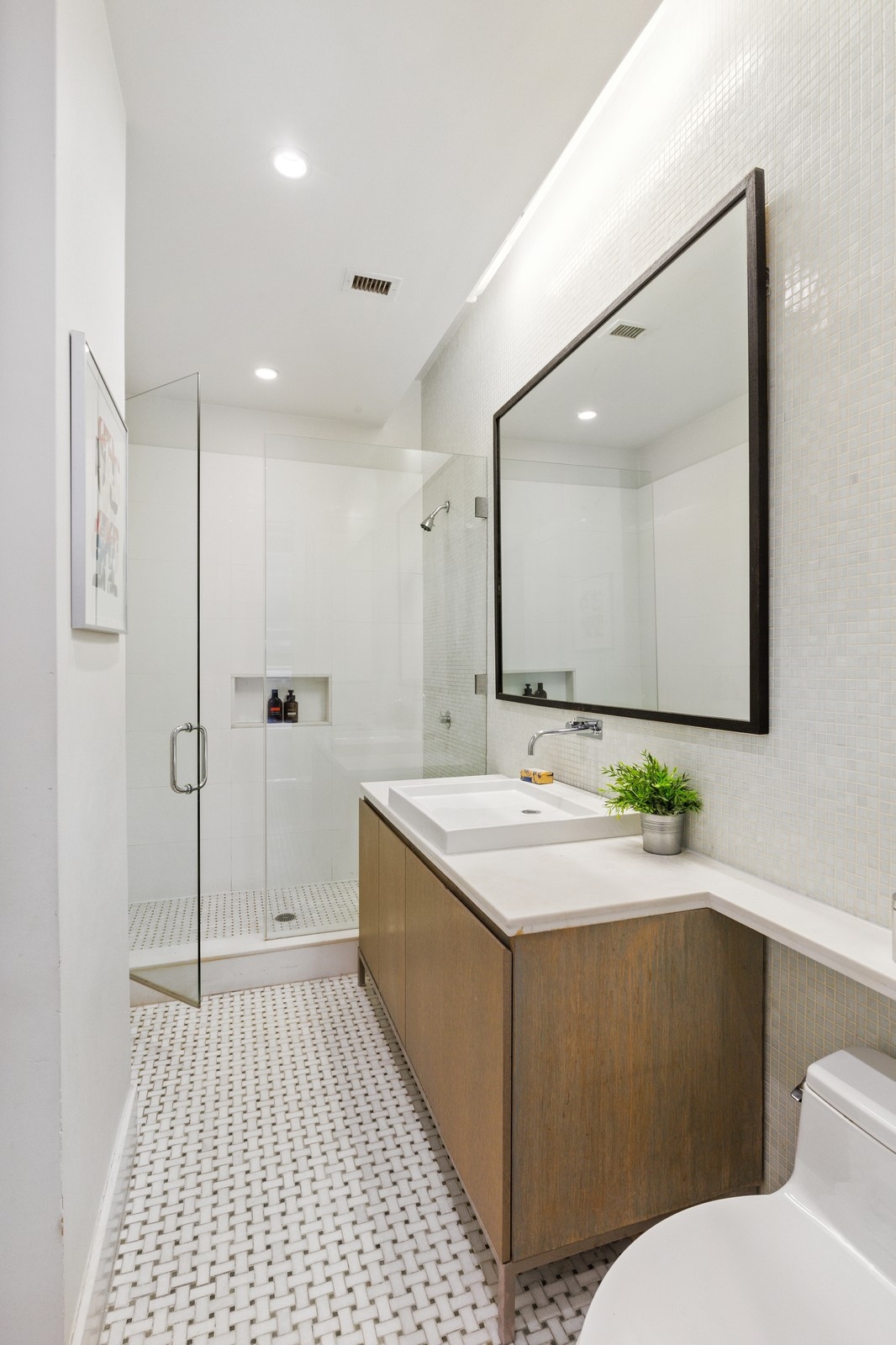 263 9th Avenue, Unit 3D Manhattan, NY 10001 - Photo 11 of 15 a bathroom with a sink a toilet a mirror and shower