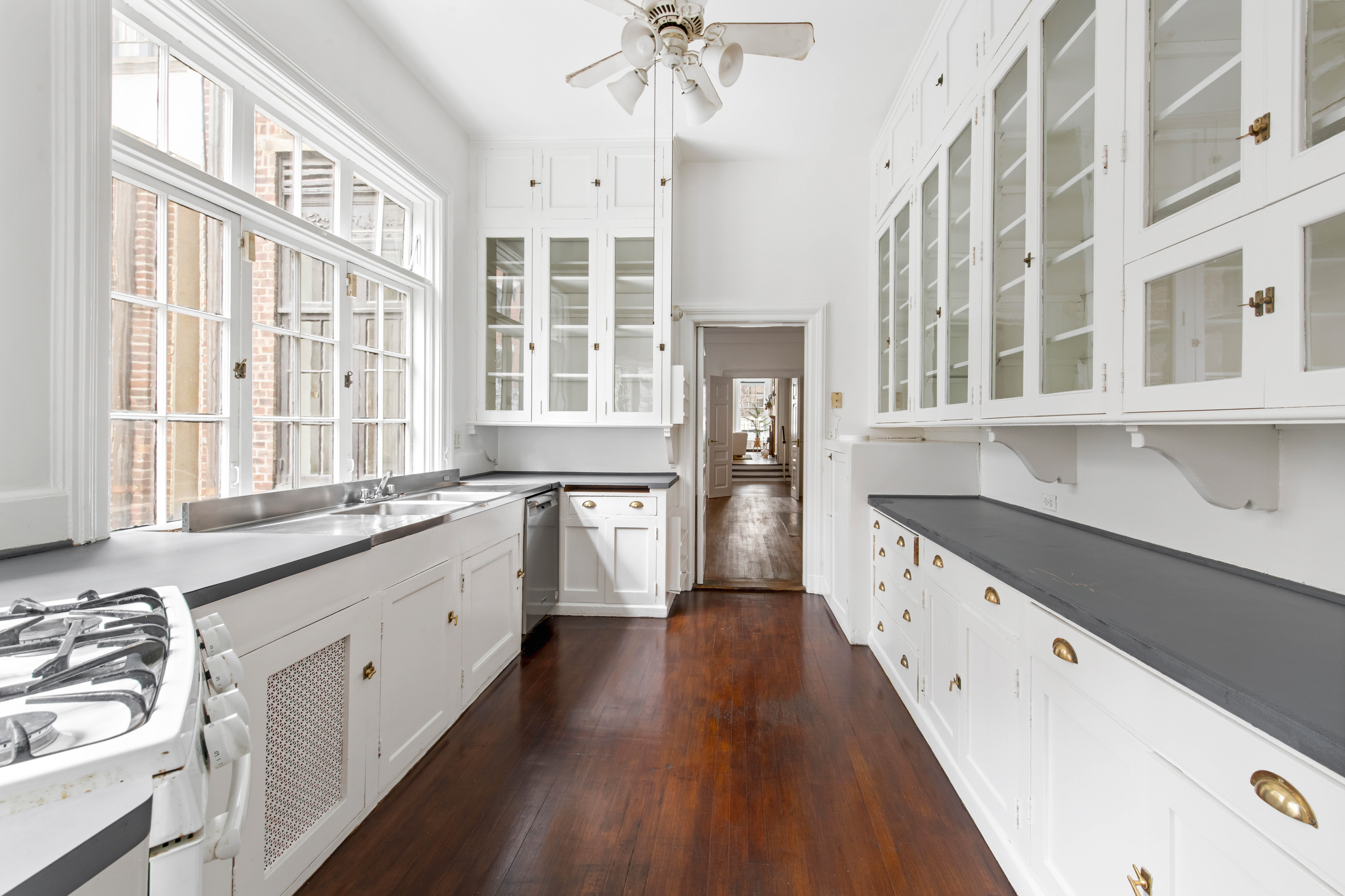 155 East 70th Street Manhattan, NY 10021 - Photo 5 of 27 a large kitchen with a lot of white cabinets and wooden floor