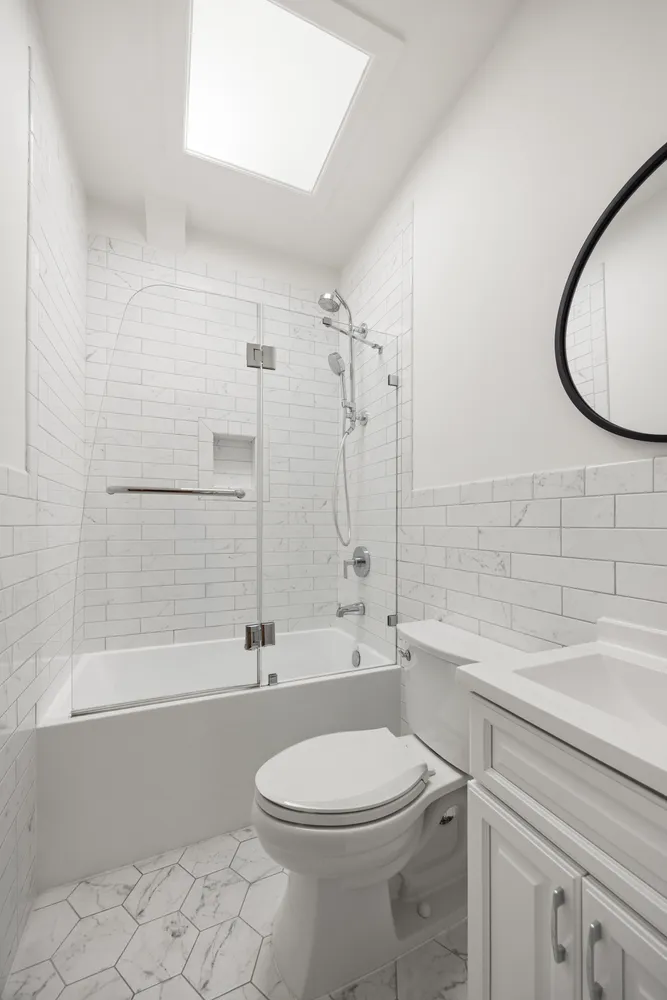 a bathroom with a toilet a sink a mirror and bathtub