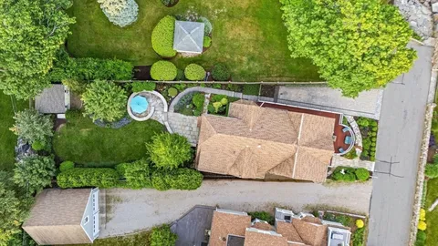 an aerial view of a house with garden space and parked car