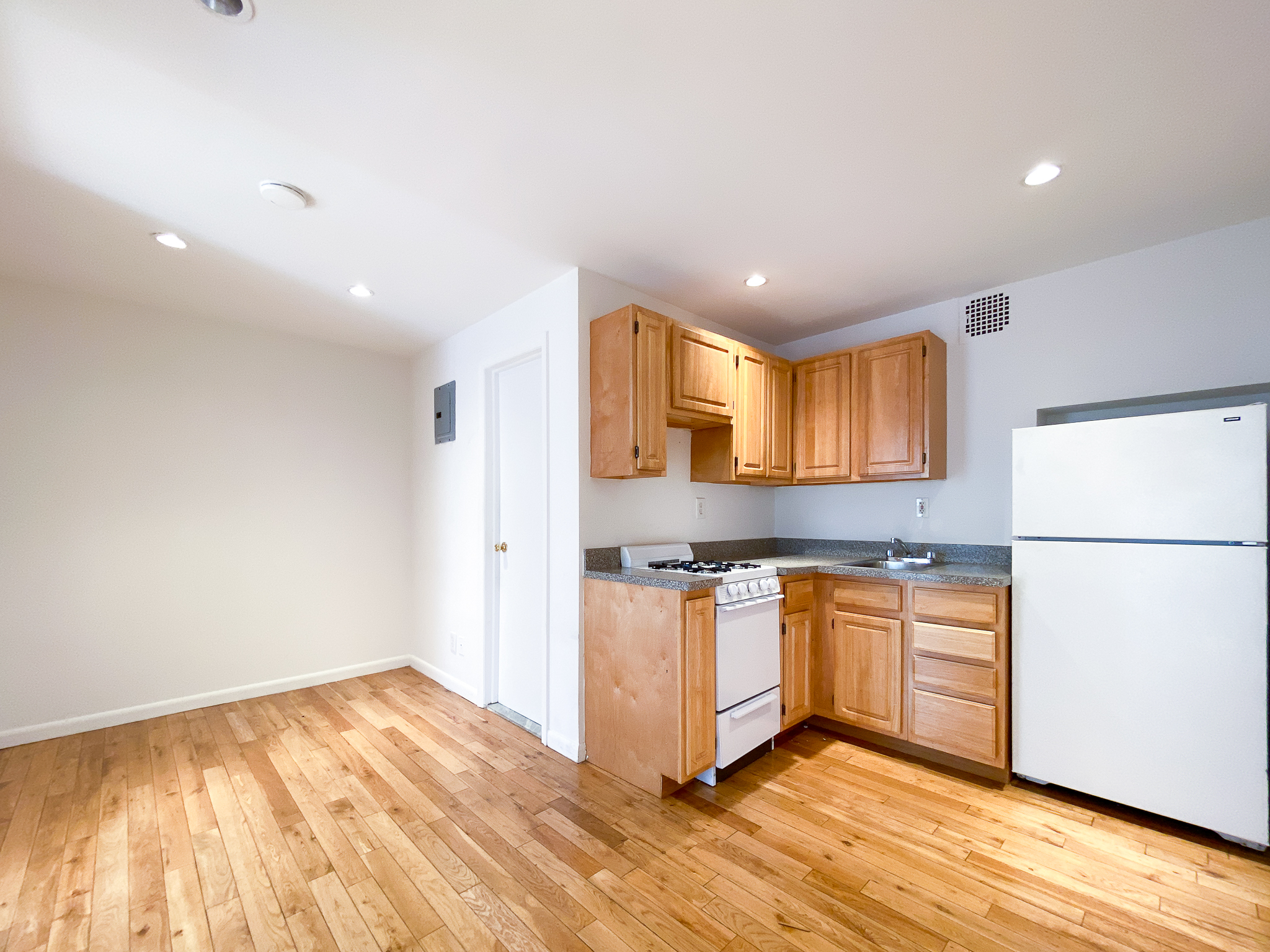 157 East 3rd Street, Unit 2B Manhattan, NY 10009 - Photo 4 of 18 a kitchen with stainless steel appliances granite countertop a refrigerator a stove a sink and a microwave