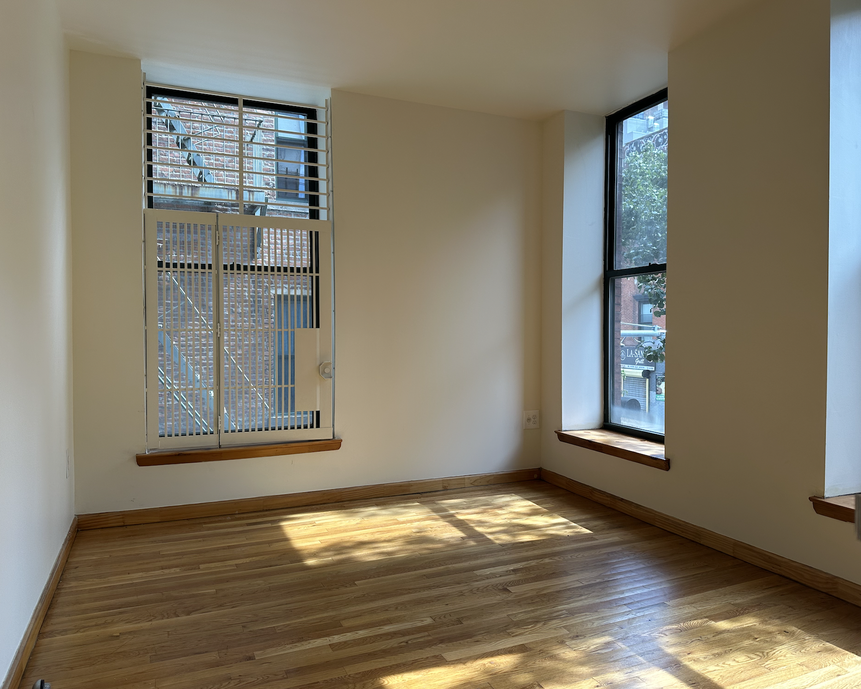 403 West 40th Street, Unit 2FE Manhattan, NY 10018 - Photo 6 of 12 a view of an empty room with wooden floor and a window