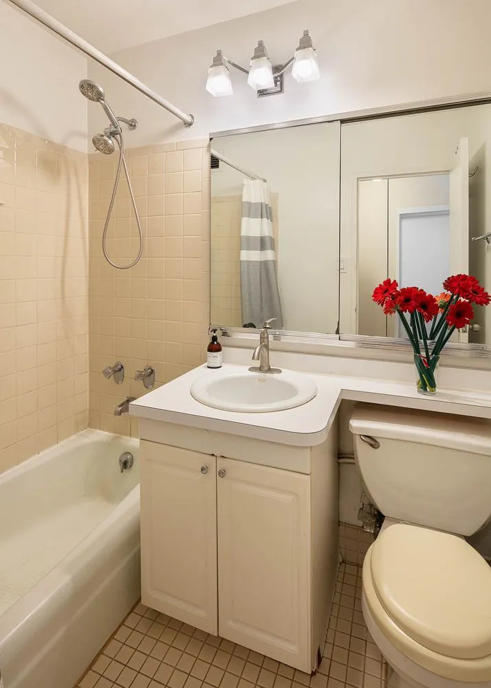 a bathroom with a granite countertop sink a toilet and shower