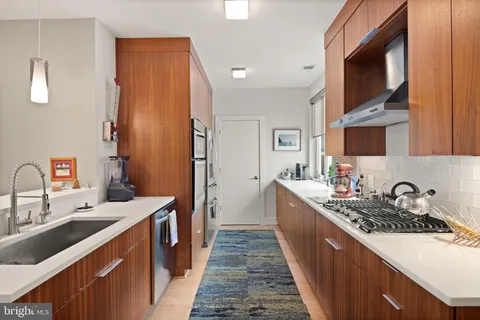 a kitchen with stainless steel appliances granite countertop a sink refrigerator and cabinets