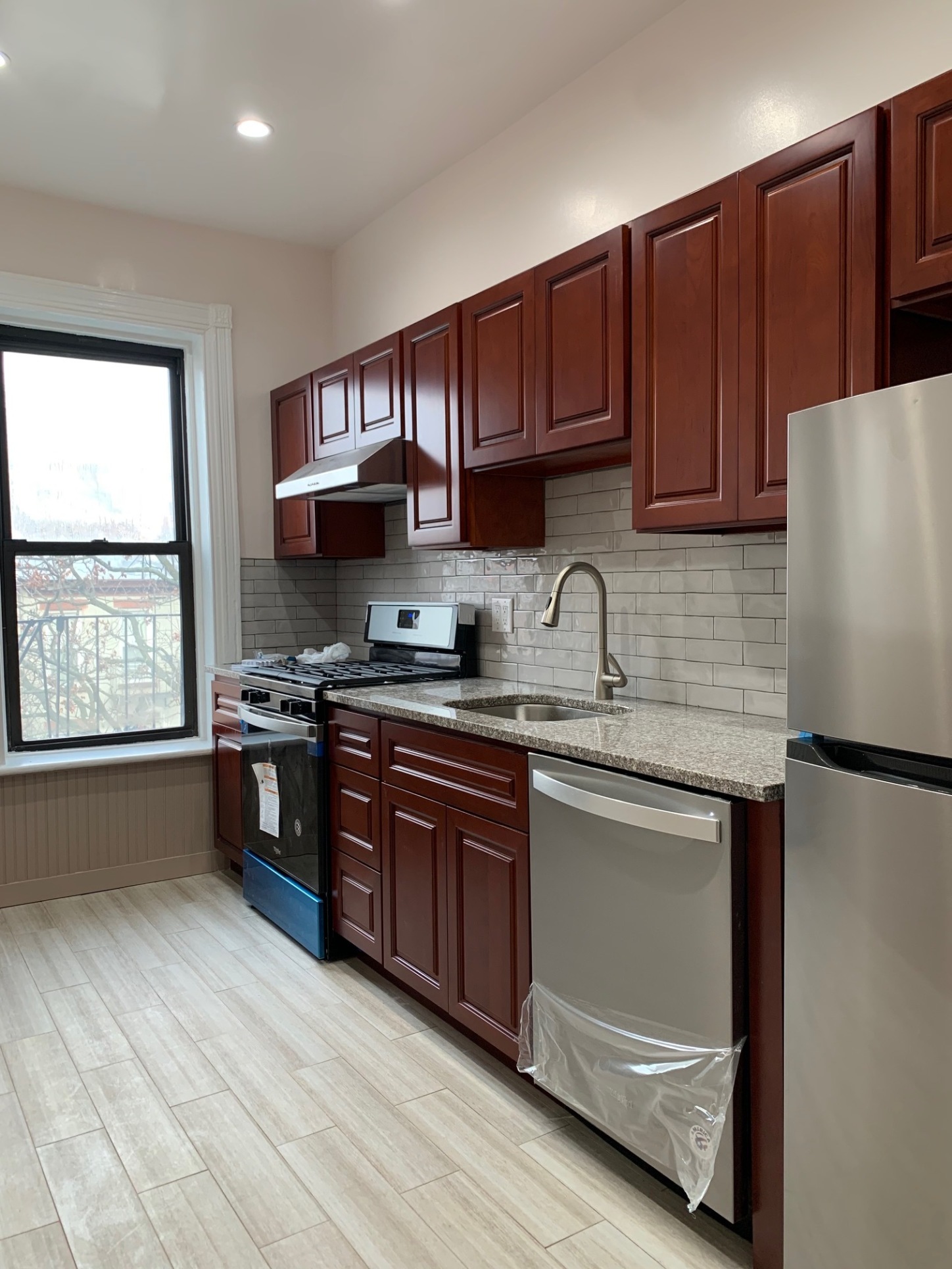 481 9th Street, Unit 4 Brooklyn, NY 11215 - Photo 23 of 33 a kitchen with stainless steel appliances granite countertop a refrigerator a sink dishwasher a stove and a refrigerator with wooden cabinets