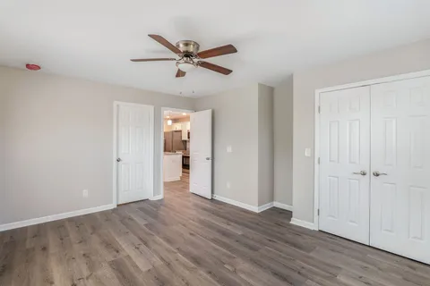 a view of empty room with wooden floor and window