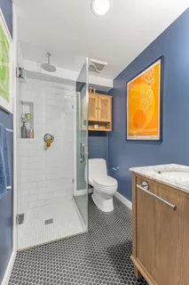 a bathroom with a toilet a window and shower