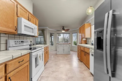 a large kitchen with stainless steel appliances kitchen island granite countertop a sink and cabinets