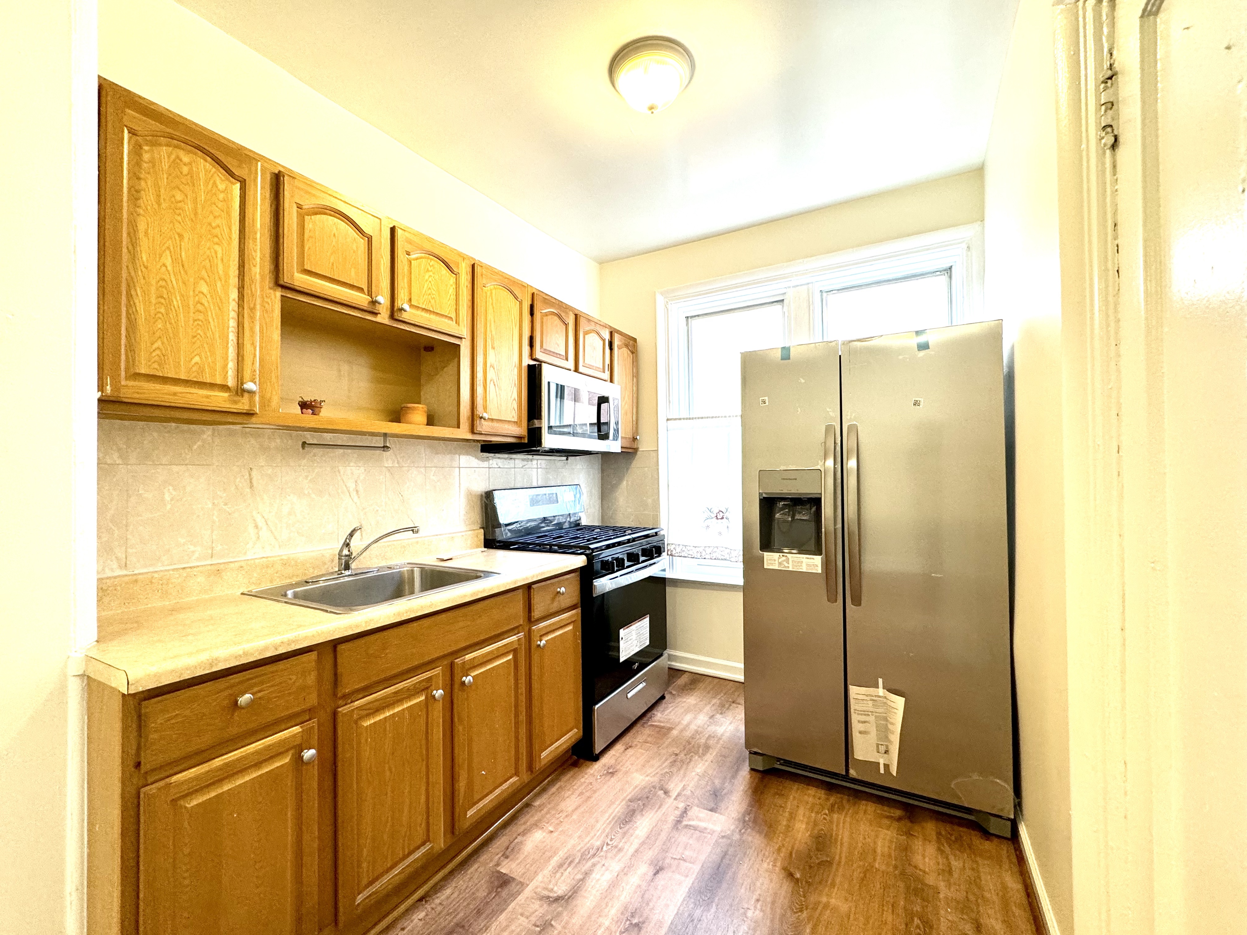 1688 Carroll Street, Unit 2 Brooklyn, NY 11213 - Photo 7 of 9 a kitchen with stainless steel appliances granite countertop a refrigerator a sink dishwasher and wooden cabinets
